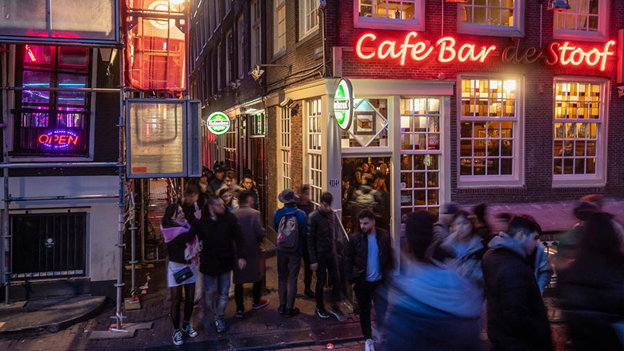 Turis menyusuri sebuah gang di kawasan lampu merah di Amsterdam, Belanda, Minggu (9/4/2023). (Peter Boer/Bloomberg)