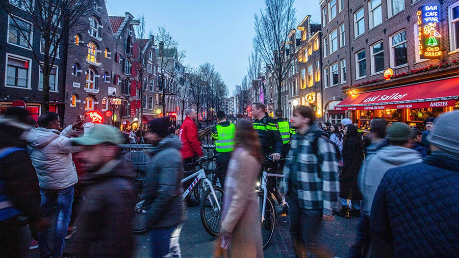 Polisi berpatroli di kawasan Oudezijds Achterburgwal di distrik lampu merah Amsterdam, Belanda, Minggu (9/4/2023). (Peter Boer/Bloomberg)