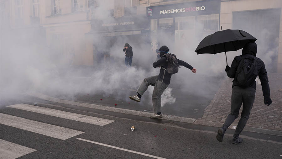 Para demonstran melemparkan flare merah di luar gedung pengadilan Dewan Konstitusional. (Nathan Laine/Bloomberg)