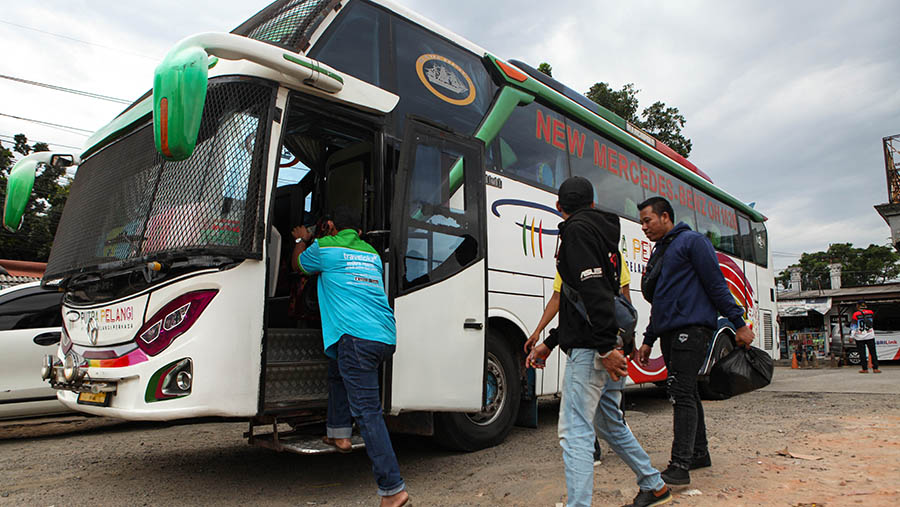 Penumpang naik kedalam bis AKAP di agen bis AKAP Pondok Pinang, Jakarta, Jumat (14/4/2023). (Bloomberg Technoz/ Andrean Kristianto)