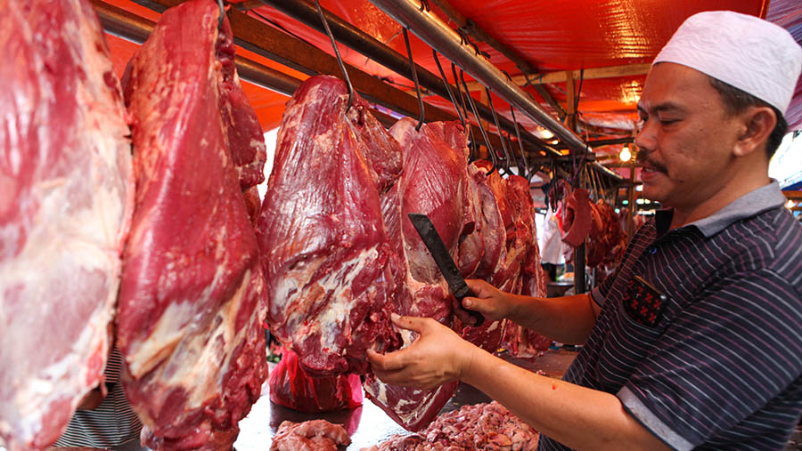 Pedagang memotong daging sapi yang dijual di Pasar Minggu, Jakarta, Selasa (18/4/2023). (Bloomberg Technoz/ Andrean Kristianto)