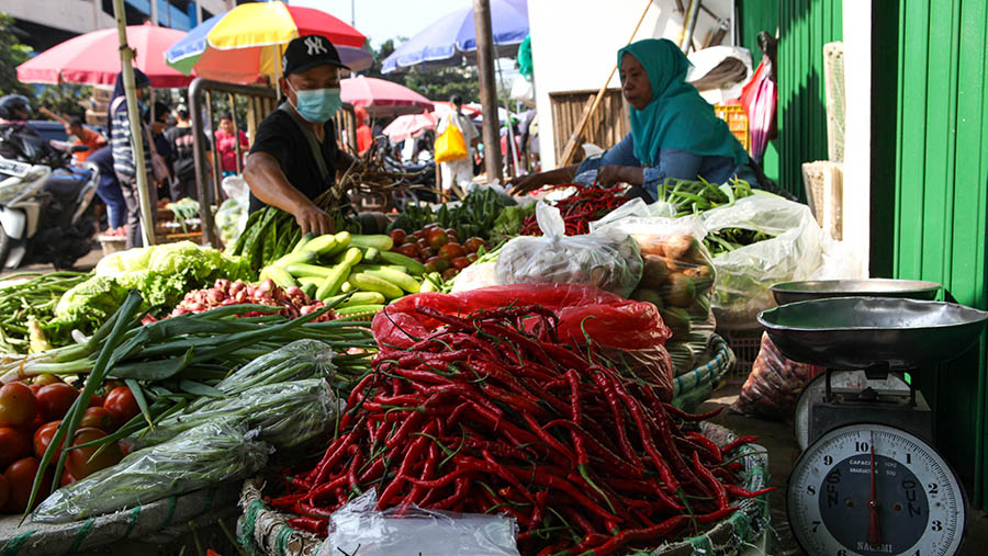 Pedagang melayani pembeli sayur dan cabai keriting merah di Pasar Minggu, Jakarta, Selasa (18/4/2023). (Bloomberg Technoz/ Andrean Kristianto)