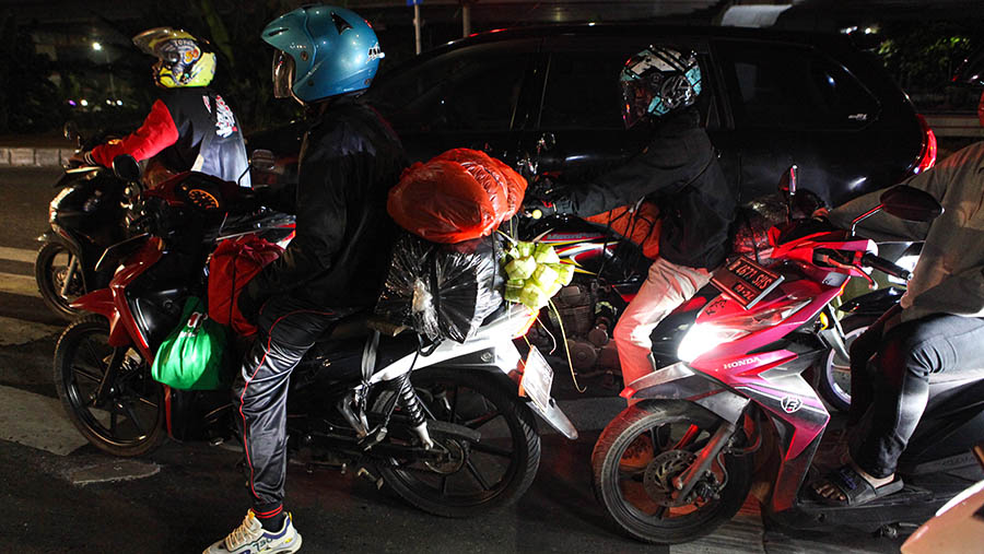 Pemudik sepeda motor melintas di kawasan Raya Kalimalang, Bekasi, Jawa Barat, Selasa Malam (18/4/2023). (Bloomberg Technoz/ Andrean Kristianto)