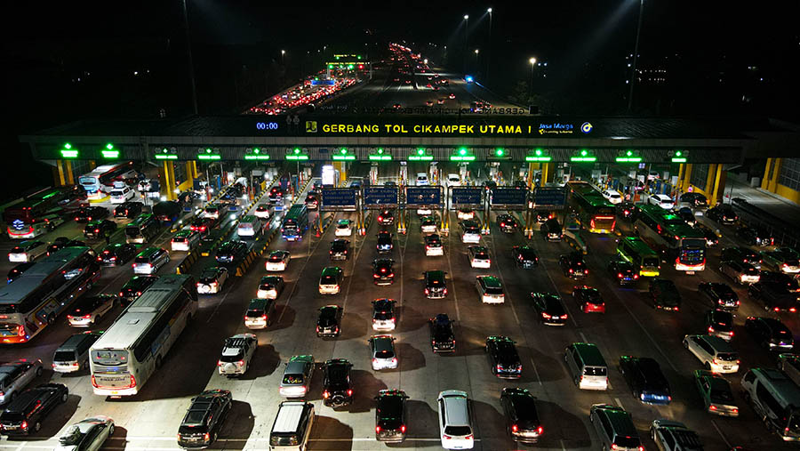Suasana antrean kendaraan di Gerbang Tol Cikampek Utama 1, Jawa Barat, Rabu malam, (19/4/2023). (Bloomberg Technoz/ Andrean Kristianto)
