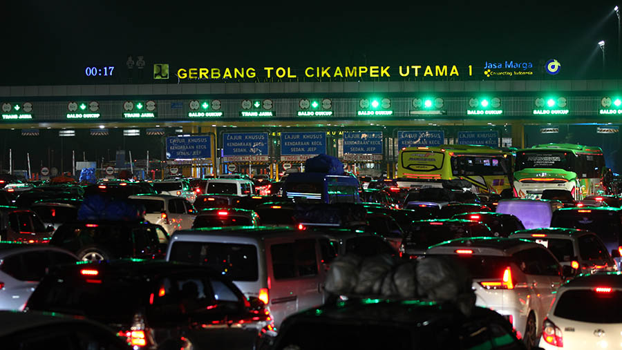 Suasana antrean kendaraan di Gerbang Tol Cikampek Utama 1, Jawa Barat, Kamis dini hari, (20/4/2023). (Bloomberg Technoz/ Andrean Kristianto)