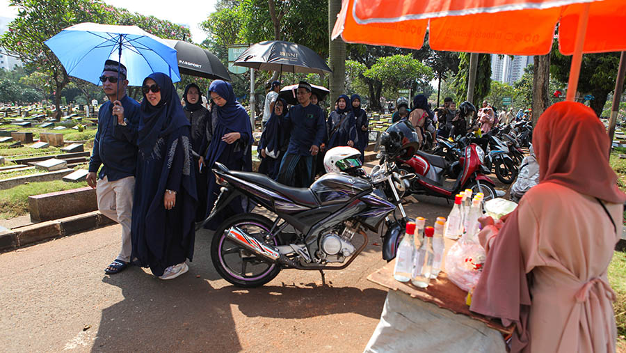 Ramainya peziarah dimanfaatkan oleh penjual bunga dan tukang besih makam untuk mengais rezeki. (Bloomberg Tehnoz/ Andrean Kristianto)