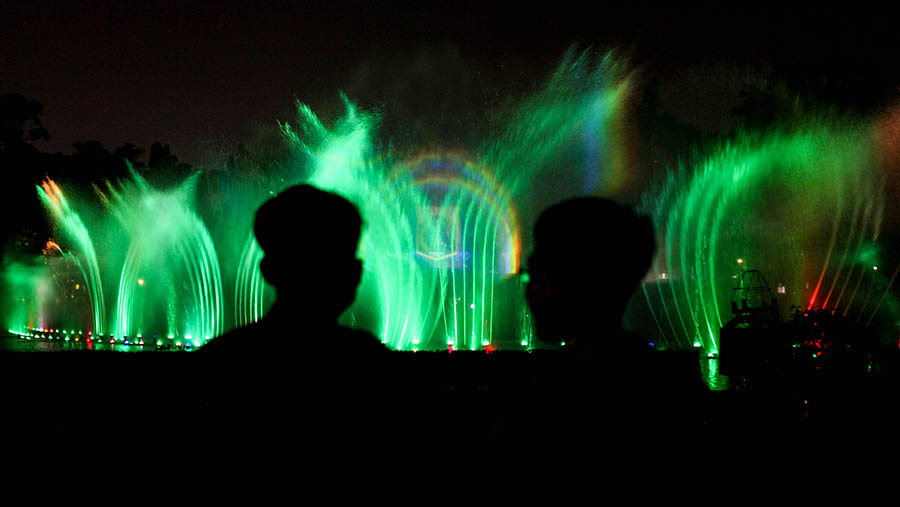 Pengunjung melihat pertunjukan air mancur menari di Monumen Nasional (Monas), Jakarta, Minggu (23/4/2023). (Bloomberg Technoz/ Andrean Kristianto)