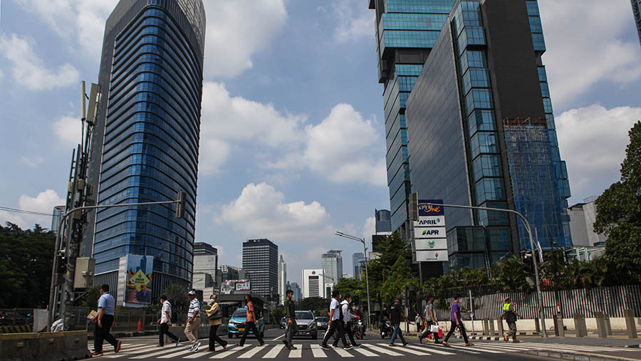 Warga menyeberang jalan di kawasan Jenderal Sudirman, Jakarta,Kamis (26/4/2023). (Bloomberg Technoz/ Andrean Kristianto)