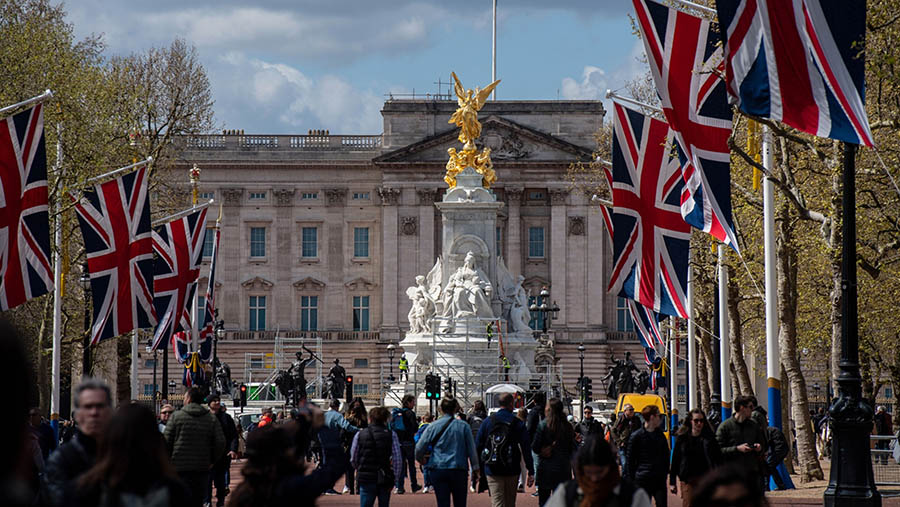 Turis berjalan di dekat Istana Buckingham menjelang penobatan Raja Charles III, di London, Inggris, Selasa (25/4/2023). (Chris J. Ratcliffe/Bloomberg)