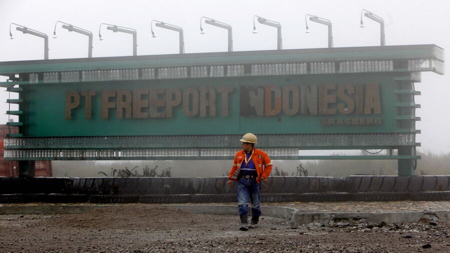 Seorang pekerja berjalan melewati tanda PT Freeport Indonesia di kompleks pertambangan tembaga dan emas Grasberg. (Dadang Tri/Bloomberg)