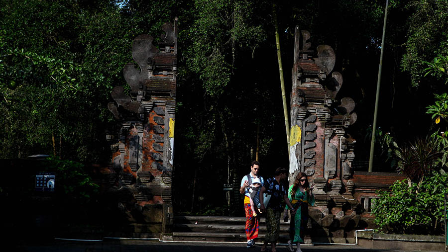 Turis asing menunjungi Pura Tirta Empul di Gianyar, Bali, Rabu (3/4/2023). (Bloomberg Technoz/ Andrean Kristianto)
