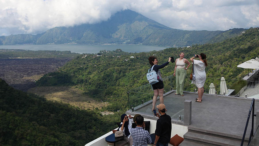 Turis asing berfoto di kawasan Kintamani, Bali, Rabu (3/4/2023). (Bloomberg Technoz/ Andrean Kristianto)