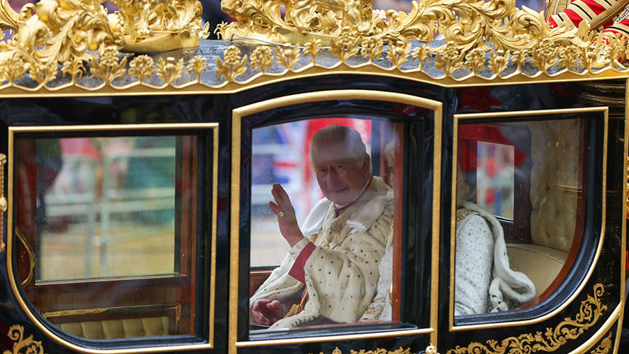Raja Charles III melambai dari kereta Diamond Jubilee saat hari penobatannya di London, Inggris, Sabtu (6/5/2023). Hollie Adams/Bloomberg