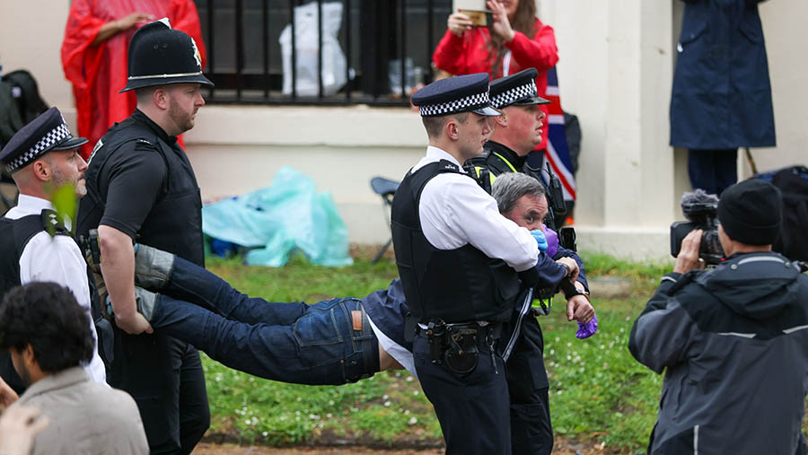 Polisi menahan pedemo aktivis iklim Just Stop Oil saat penobatan Raja Charles III di London, Inggris, Sabtu (6/5/2023). (Hollie Adams/Bloomberg)