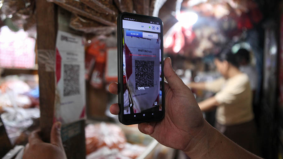 Pembeli melakukan pembayaran digital (QRIS) di Pasar Minggu, Kamis (11/5/2023). (Bloomberg Technoz/ Andrean Kristianto)
