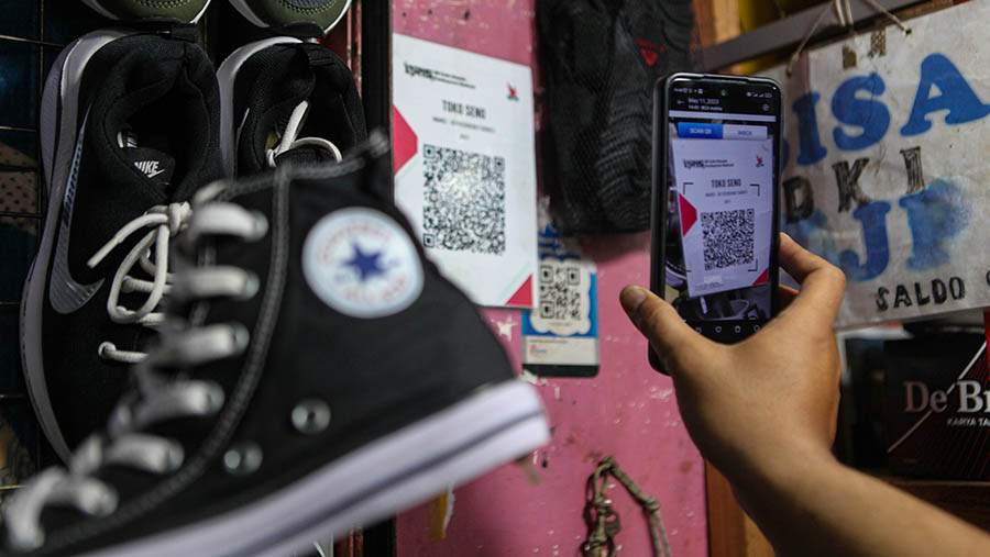 Pembeli melakukan pembayaran digital (QRIS) di Pasar Minggu, Kamis (11/5/2023). (Bloomberg Technoz/ Andrean Kristianto)