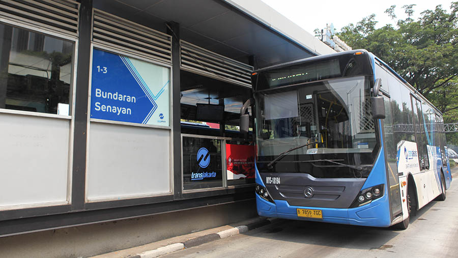 Bus Transjakarta menaikkan penumpang di halte Transjakarta Bundaran Senayan, Jakarta, Selasa (30/5/2023) (Bloomberg Technoz/Andrean Kristianto)