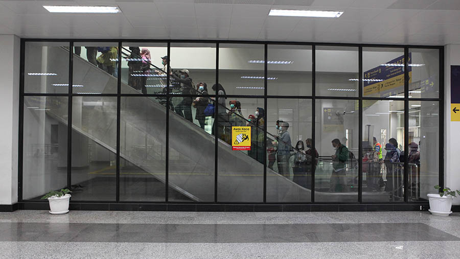Penumpang KRL Commuter line menaiki eskalator di Stasiun Manggarai, Selasa (30/5/2023). (Bloomberg Technoz/ Andrean Kristianto)