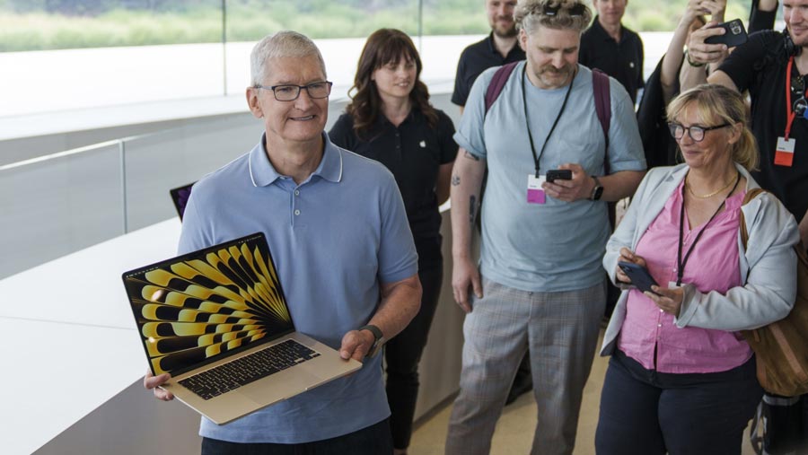 CEO Apple Inc., Tim Cook memegang Apple MacBook Air 15 inci di Cupertino, California, AS, Senin (5/6/2023). (Philip Pacheco/Bloomberg)