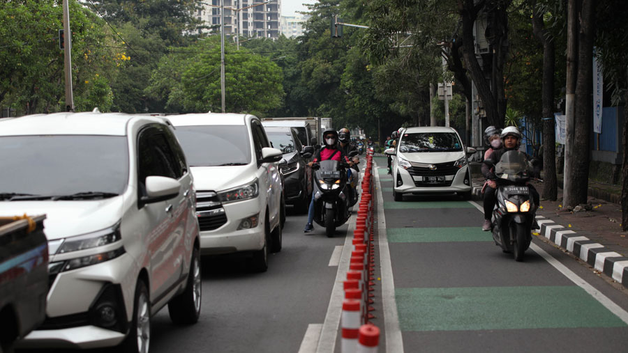 Tak hanya kendaraan roda dua, terlihat juga mobil ikut menerobos jalur yang seharusnya digunakan oleh pesepeda.(Bloomberg Technoz/ Andrean Kristianto)