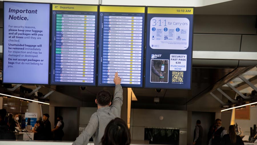 Penumpang melihat monitor keberangkatan di Bandara LaGuardia (LGA), New York, AS, Kamis (8/6/2023). (Michael Nagle/Bloomberg)