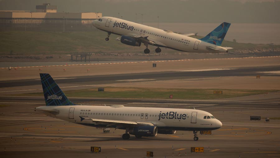 Pesawat lepas landas saat asap kebakaran Kanada menyelimuti Bandara LaGuardia (LGA), New York, AS, Kamis (8/6/2023). (Michael Nagle/Bloomberg)