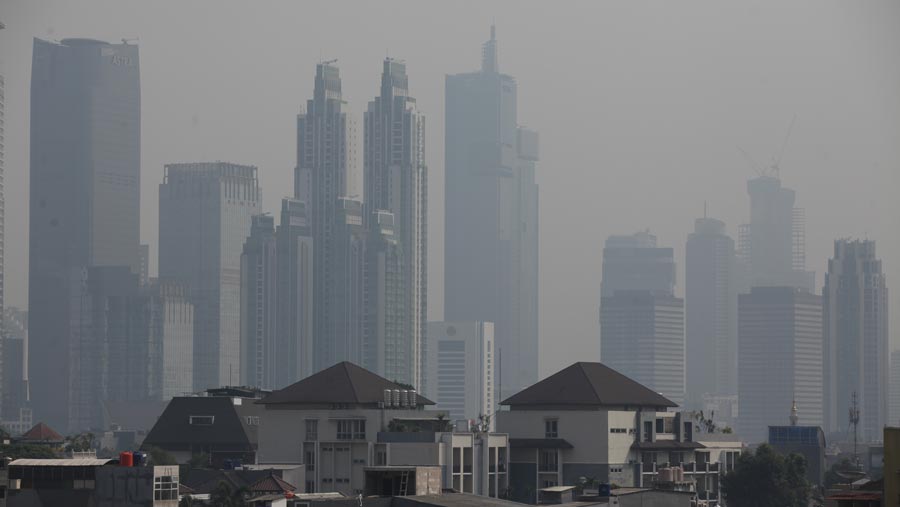 Suasana gedung bertingkat yang diselimuti polusi di Jakarta, Senin (12/6/2023).(Bloomberg Technoz/ Andrean Kristianto)