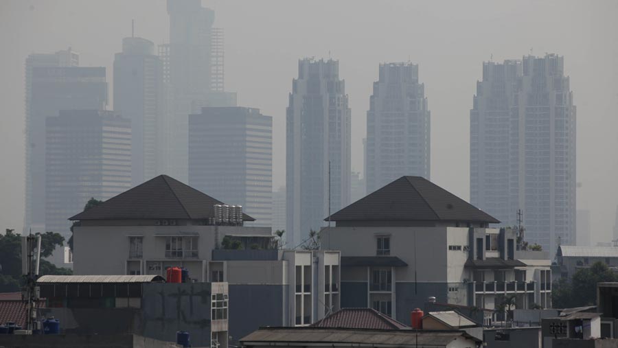 Suasana gedung bertingkat yang diselimuti polusi di Jakarta, Senin (12/6/2023).(Bloomberg Technoz/ Andrean Kristianto)