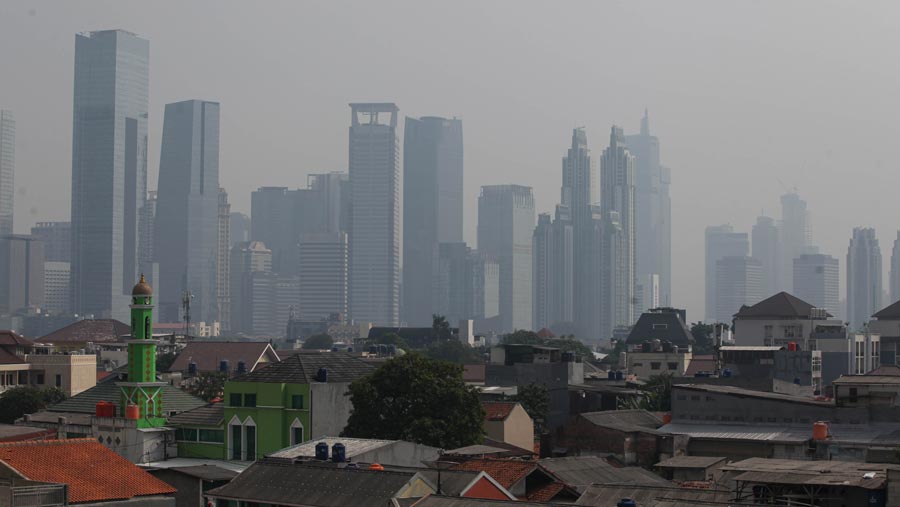 Suasana gedung bertingkat yang diselimuti polusi di Jakarta, Senin (12/6/2023).(Bloomberg Technoz/ Andrean Kristianto)