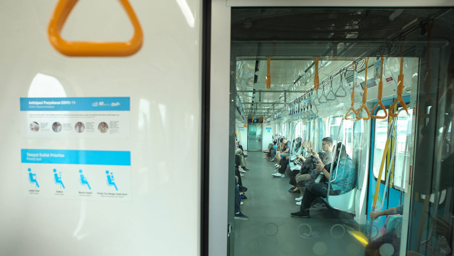 Meskipun aturan penggunaan telah dicabut, masih banyak penumpang yang masih tetap menggunakan masker. (Bloomberg Technoz/ Andrean Kristianto)