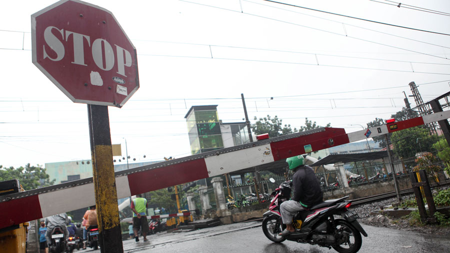 Pengendara menerobos palang perlintasan kereta api di dekat Stasiun Pasar Minggu, Jakarta, Jumat (16/6/2023). (Bloomberg Technoz/ Andrean Kristianto)