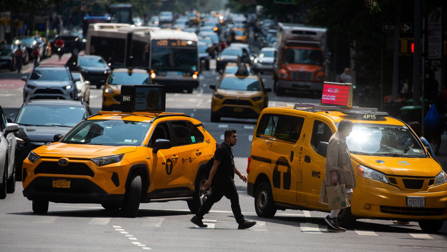Pejalan kaki menyeberang jalan melewati lalu lintas di kawasan Midtown New York, AS, Sabtu (17/6/2023). (Michael Nagle/Bloomberg)