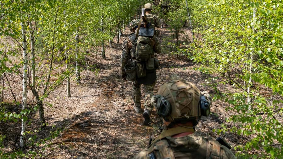 Mereka berlatih perang dengan menggunakan senjata menyusuri hutan hingga parit. (Seth Herald/Bloomberg)
