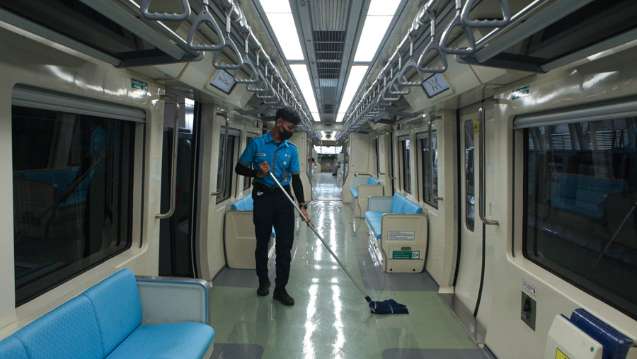 Pekerja membersihkan gerbong LRT Jabodebek di Stasiun LRT Dukuh Atas, Jakarta, Rabu (28/6/2023). (Bloomberg Technoz/ Andrean Kristianto)