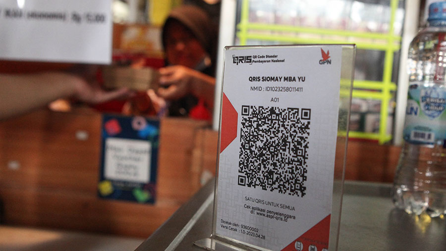 Warga melakukan pembayaran menggunakan QRIS saat berbelanja di Pasar Santa, Jakarta, Senin (3/7/2023). (Bloomberg Technoz/ Andrean Kristianto)