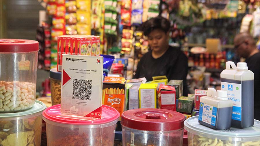 Kode batang QRIS terpampang di salah satu penjual di Pasar Santa, Jakarta, Senin (3/7/2023). (Bloomberg Technoz/ Andrean Kristianto)
