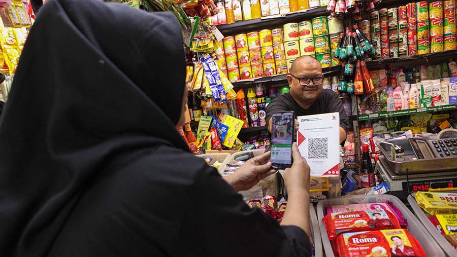 Warga melakukan pembayaran menggunakan QRIS saat berbelanja di Pasar Santa, Jakarta, Senin (3/7/2023). (Bloomberg Technoz/ Andrean Kristianto)