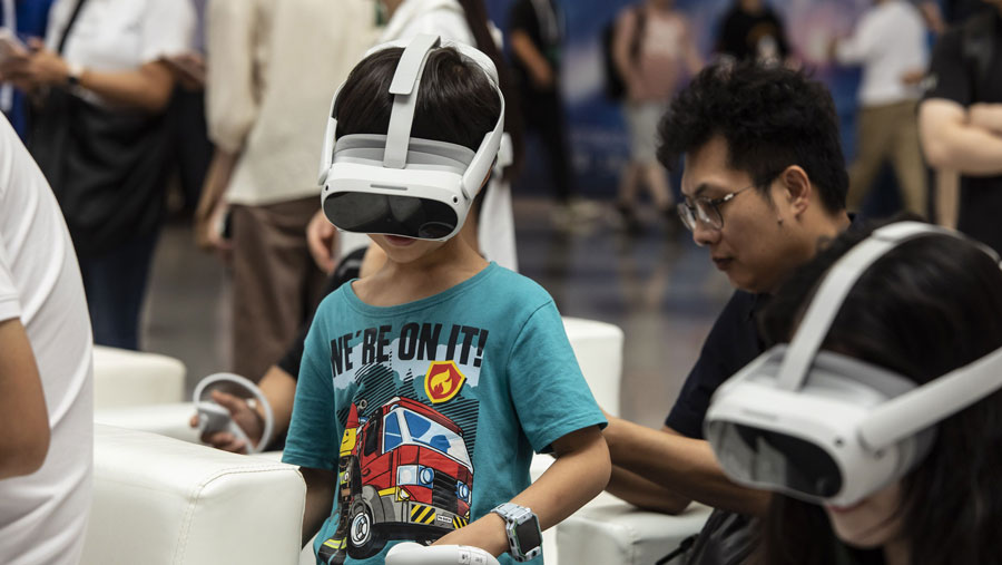 Peserta mencoba headset virtual reality di World Artificial Intelligence Conference (WAIC) di Shanghai, China, Kamis (6/7/2023) (Qilai Shen/Bloomberg)