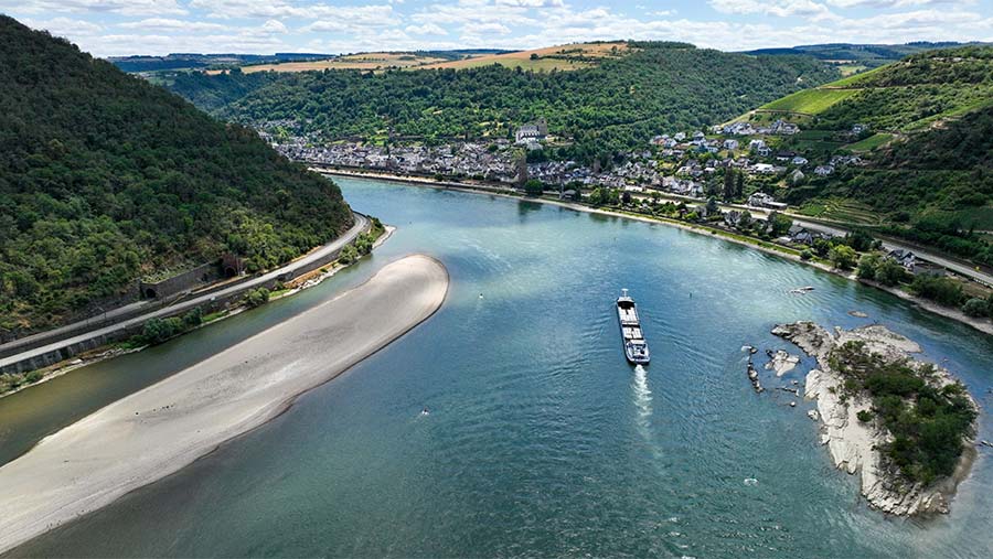 Sebuah tongkang berlayar di sepanjang Sungai Rhine antara Oberwesel dan Loreley, Jerman, Kamis (6/7/2023). (Alex Kraus/Bloomberg)
