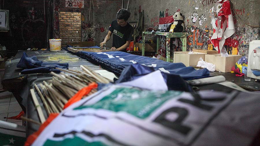 Pekerja menyelesaikan pembuatan bendera partai politik jelang pemilu di Bukit Duri, Jakarta, Senin (10/7/2023). (Bloomberg Technoz/Andrean Kristianto)