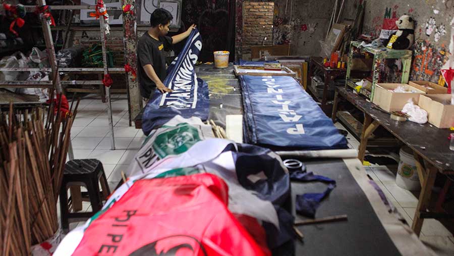 Pekerja menyelesaikan pembuatan bendera partai politik jelang pemilu di Bukit Duri, Jakarta, Senin (10/7/2023). (Bloomberg Technoz/Andrean Kristianto)