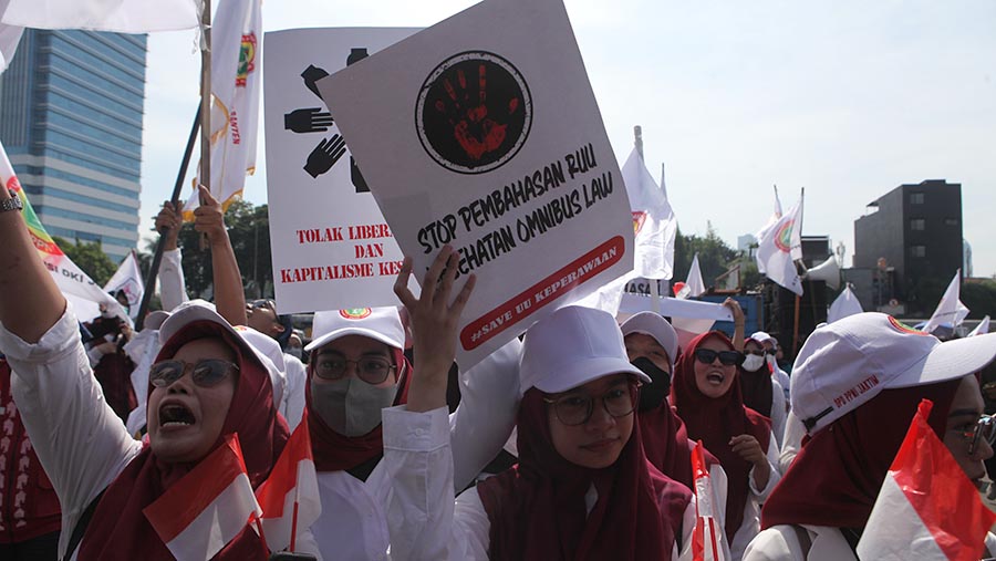 Aksi unjuk rasa tenaga medis menentang RUU Kesehatan di depan gedung MPR/DPR, Jakarta, Selasa (11/7/2023). (Bloomberg Technoz/ Andrean Kristianto)