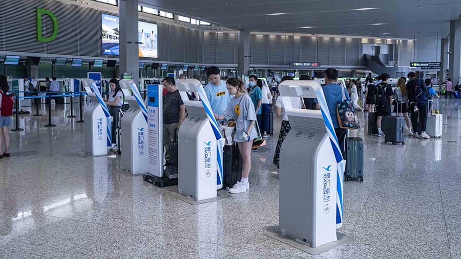 Penumpang melakukan check-in untuk penerbangan di Bandara Internasional Hongqiao di Shanghai, China, Selasa (11/7/2023). (Raul Ariano/Bloomberg)