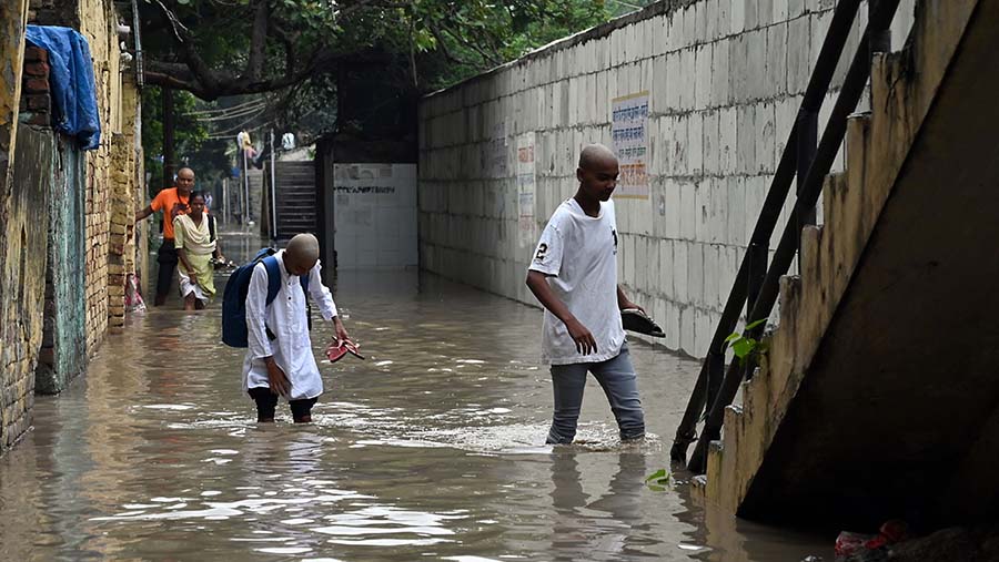 Warga melewati banjir akibat hujan lebat di New Delhi, India, Selasa (11/7/2023). (Prakash Singh/Bloomberg)