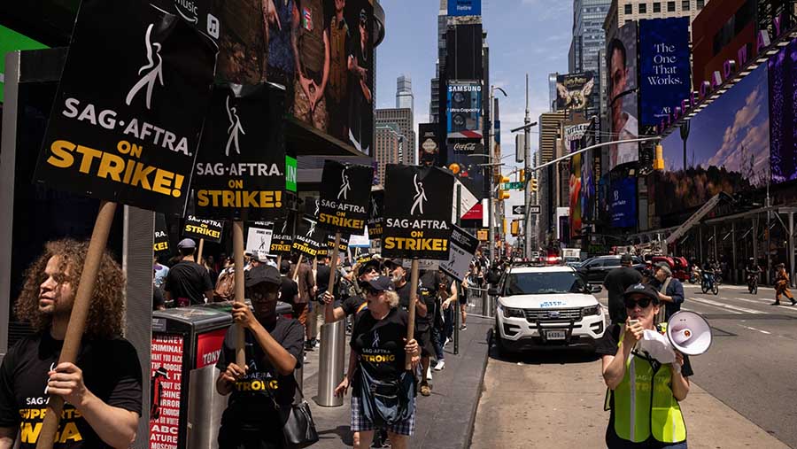 Sejumlah penulis dan aktor melakukan demo di Times Square di New York, AS, Jumat (14/7/2023). (Yuki Iwamura/Bloomberg)