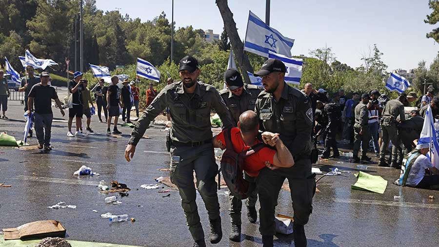 Polisi membawa pedemo yang memblokir jalan di luar parlemen Israel, di Yerusalem, Israel, Senin (24/7/2023). (Kobi Wolf/Bloomberg)