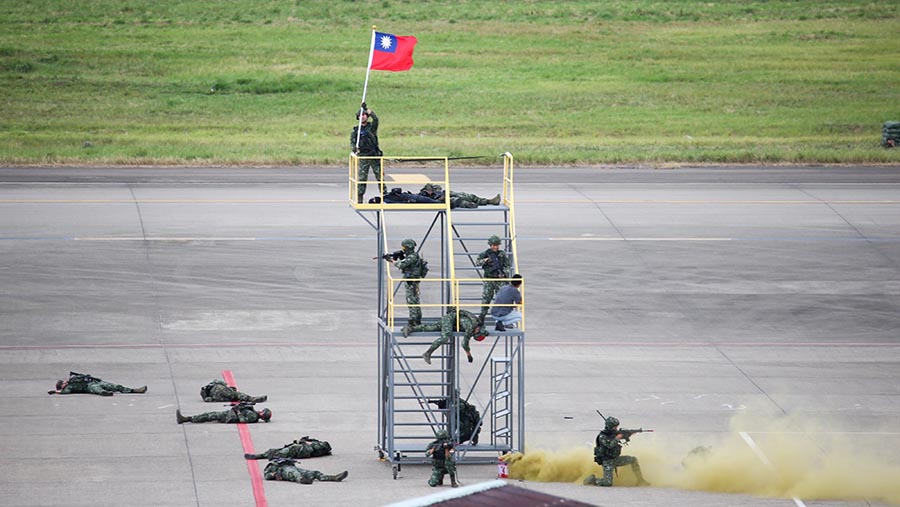 Para tentara mengibarkan bendera Taiwan sebagai tanda keberhasilan pertahanan bandara dalam simulasi ini. (I-Hwa Cheng/Bloomberg)