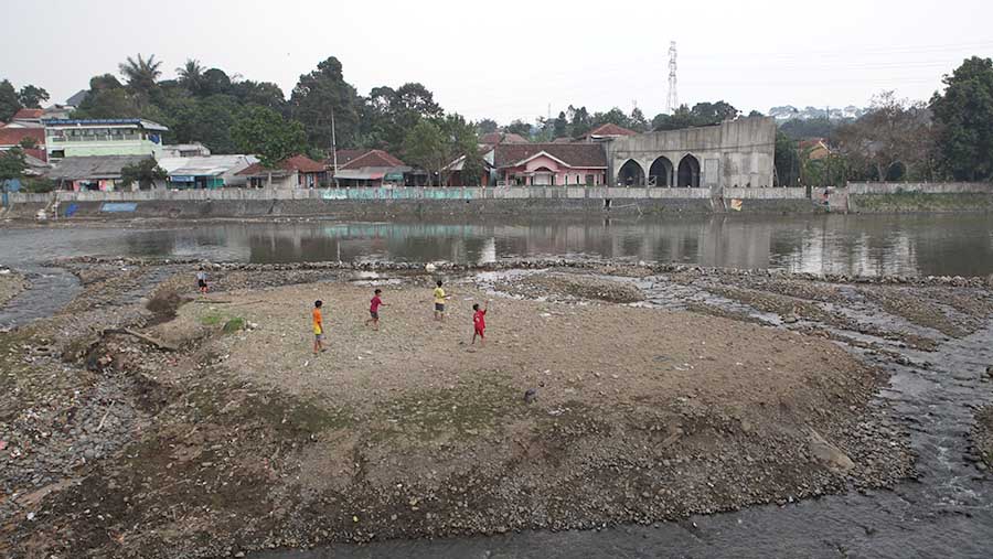 Penyusutan air dimanfaatkan oleh sejumlah anak-anak untuk bermain layang-layang.. (Bloomberg Technoz/ Andrean Kristianto)