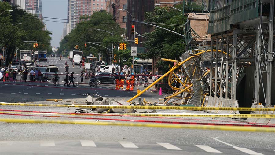 Sebuah crane/derek konstruksi terbakar dan roboh di tengah Manhattan pada hari Rabu pagi. (Jeenah Moon/Bloomberg)