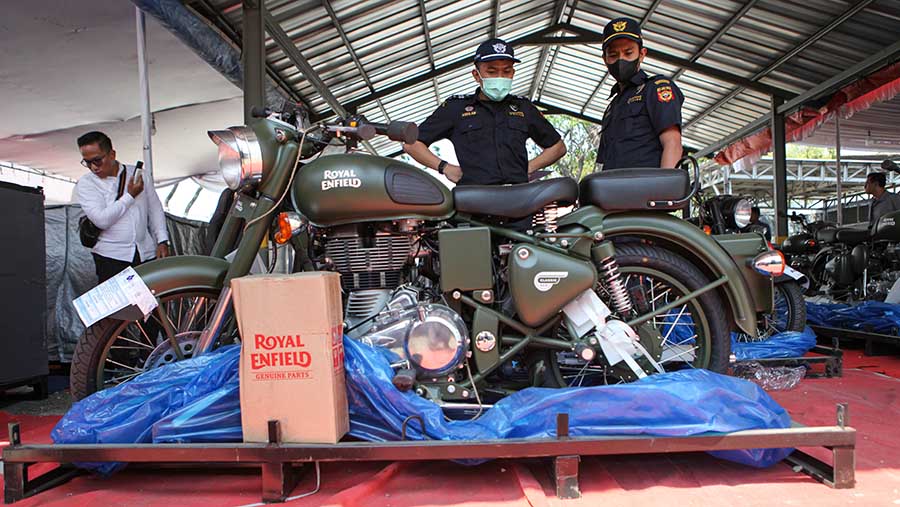 Petugas Bea Cukai mengecek motor Royal Enfield yang dilelang di gudang TPP, Jakarta, Selasa (1/8/2023). (Bloomberg Technoz/Andrean Kristianto)